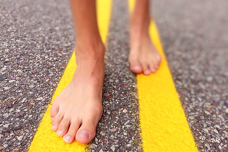 selective focus of person's feet standing on a concrete road thumbnail