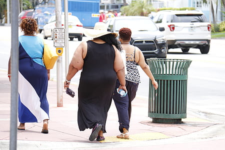 woman wearing black sleeveless dress walking during daytime thumbnail