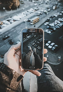 person standing on building while taking picture thumbnail