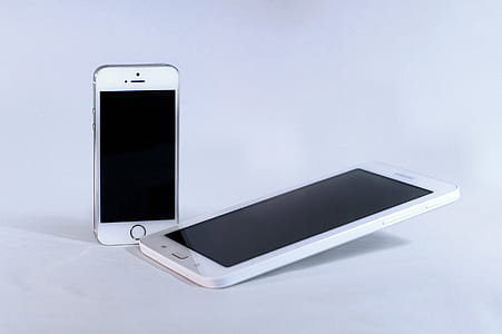 white Android tablet computer and silver iPhone 5s thumbnail