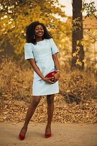 Smiling Woman Standing Outdoors Beside Grasses and Trees thumbnail