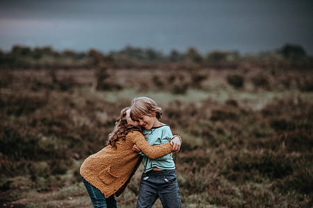 girl and child playing outside photography during daytime thumbnail