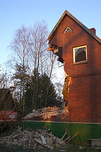 wrecked brown brick house under sunny sky thumbnail