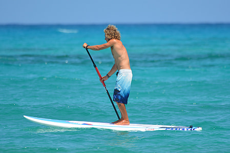 man on paddle board under clear blue sky thumbnail