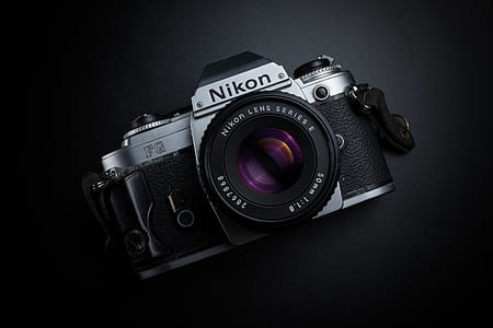 black Nikon SLR camera on black surface thumbnail