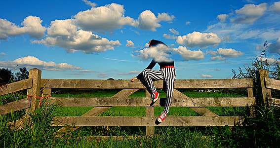 person sitting on brown fence thumbnail