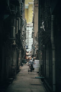 man standing inside alley under yellow textiles thumbnail