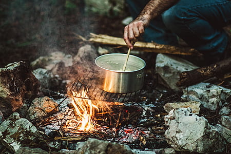 person holding stick while cooking on gray stainless steel pot thumbnail