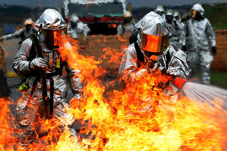 men holding hose with water pointing to the fire thumbnail