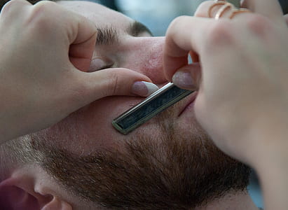 person shaving beard of man thumbnail