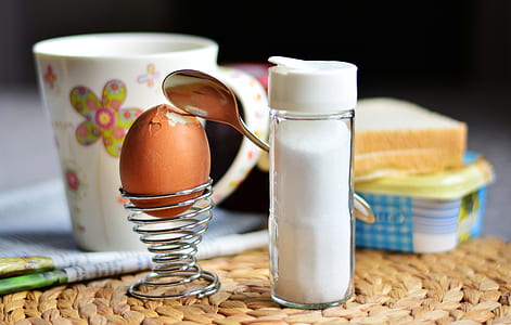 silver spiral egg holder placed beside salt condiment shaker thumbnail