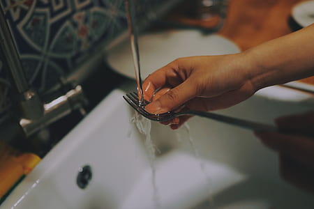 person washing stainless steel fork thumbnail