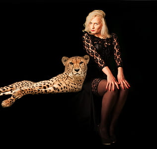 woman wearing black long-sleeved lace mini dress sitting near leopard illustration thumbnail