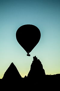 silhouette of hot air balloon flying distance with mountains at blue hour thumbnail