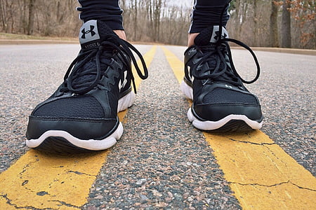 person wearing pair of black-and-white Under Armour running shoes thumbnail