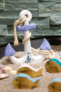 close-up photography of white and purple anchor on white sand near brown wooden fish thumbnail