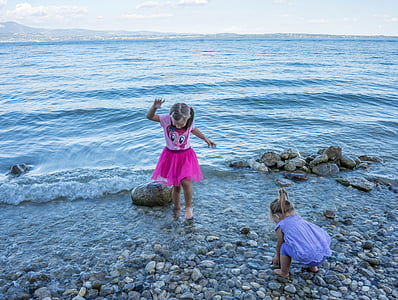 girl in purple and pink dress standing on seashore during daytime thumbnail