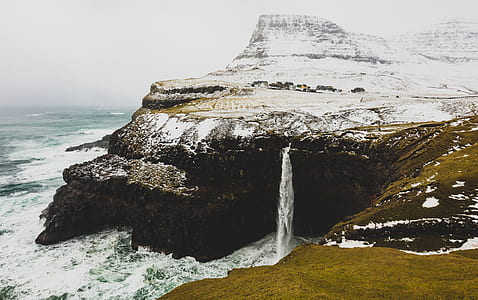 snow covered cliff beside ocean thumbnail