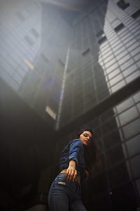 woman standing beside black building during daytime thumbnail