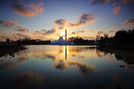 white concrete mosque near body of water at golden hour thumbnail