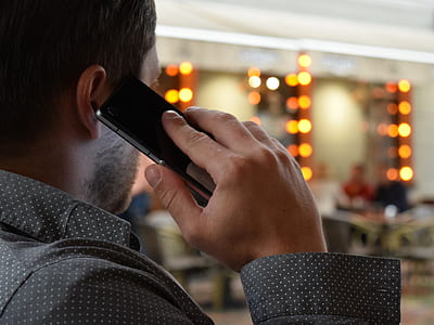 man holding smartphone wearing dress shirt thumbnail