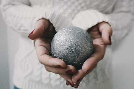 round silver ball on person's hand thumbnail