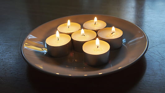 lit tealight candles on plate thumbnail