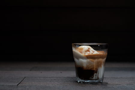 clear glass filled with latte on brown surface thumbnail
