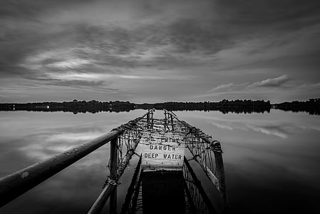 grayscale photography of bridge below body of water thumbnail