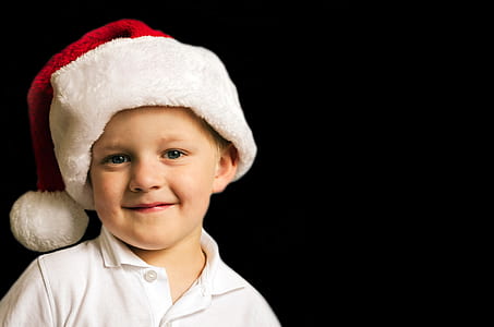 boy wearing white polo shirt and Santa hat on black background thumbnail