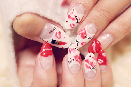 closeup photo of person's nails with red lips nail polishes thumbnail