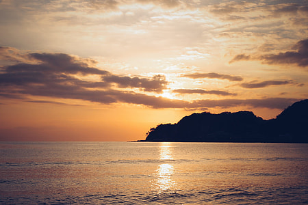 landscape photo of rocks near ocean during sunset thumbnail