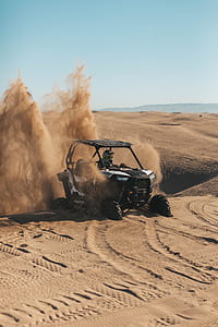 man riding on black and gray dune buggy on desert thumbnail