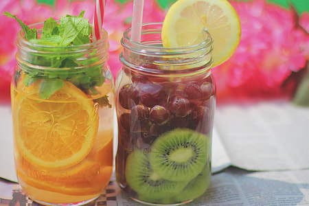 two clear glass jars with orange and grapes fruits juices thumbnail