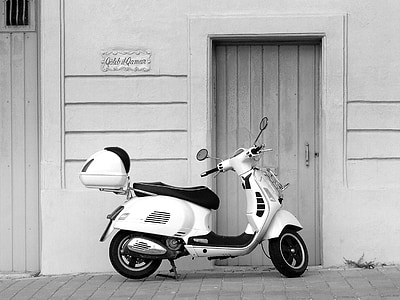 motor scooter parked beside closed door grayscale photography thumbnail