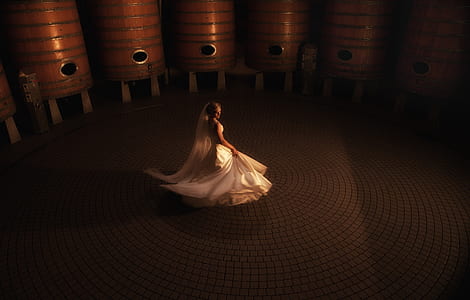 photography of woman in white wedding gown standing near brown wooden tank thumbnail