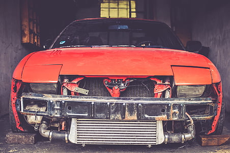 closeup photography of orange car parked between concrete walls thumbnail