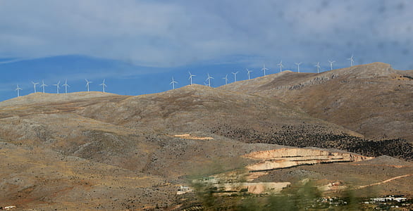 white wind turbine on hills thumbnail