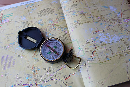round gold-colored compass on map thumbnail