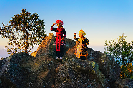 two children standing on rock at daytime thumbnail