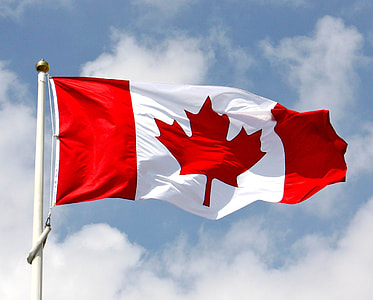 waving Canada flag on pole during day thumbnail