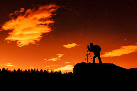 silhouette photo of person standing on cliff while using camera thumbnail