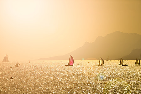 brown and pink sail boat above body of water thumbnail