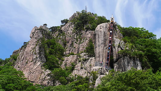 group of people climbing a mountain at daytime thumbnail