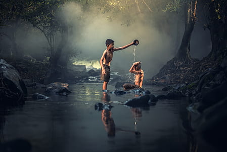 boy pouring water on person while on the river thumbnail