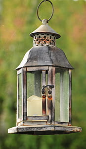 white candle inside gray metal lantern case thumbnail