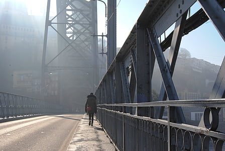 person walking on bridge during daytime thumbnail