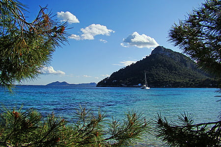 photo of boat on body of water near mountain thumbnail