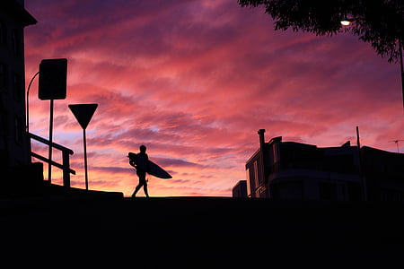 silhouette of person carrying surfboard thumbnail