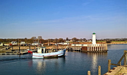 blue boat near lighthouse thumbnail